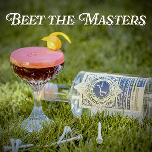 Red cocktail with a pink rim and yellow cherry on grass, bottle of T3 Vodka nearby, text 'Beet the Masters' above