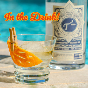 Cocktail with an orange peel garnish, bottle in the background, text 'In the Drink!'